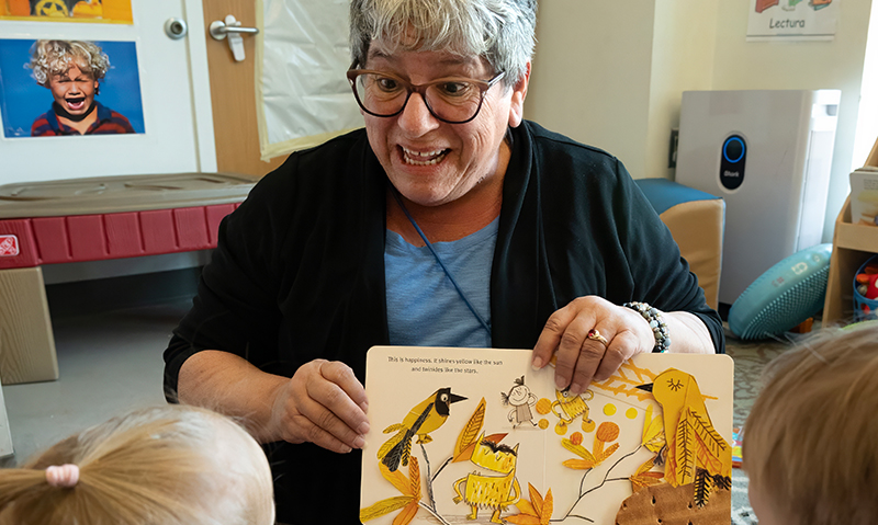 Photo of Jo Ann reading a book to students