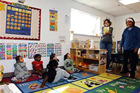 Photo of a classroom with children and teachers preparing for story time